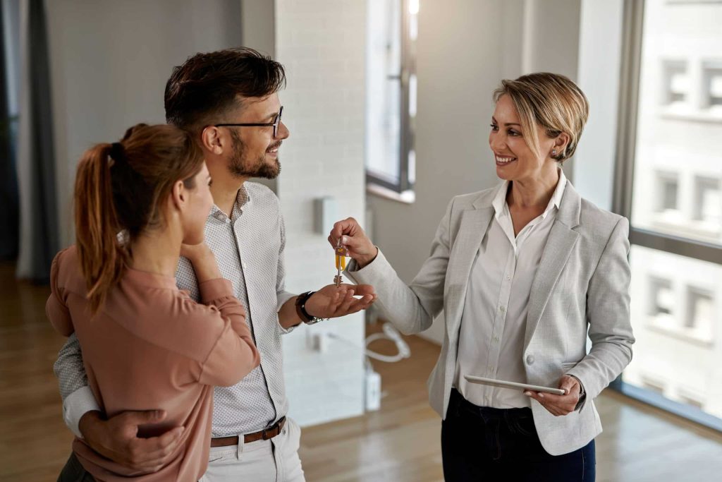 Agent handing over keys to buyers.