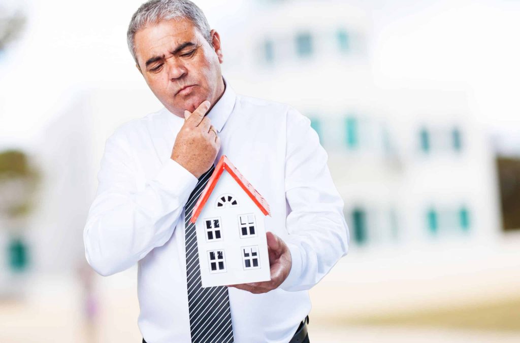 Man holding a small house model.