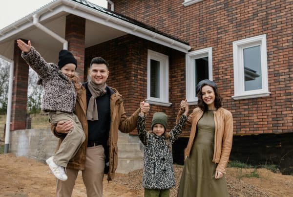Family posing in front of house.
